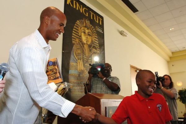 Miami Dolphins star Jason Taylor, left, shakes hands with a Liberty City Charter School student during a surprise presentation to South Florida elementary through eighth grade students at the "Tutankhamun and the Golden Age of the Pharaohs" museum exhibition at the Museum of Art/Fort Lauderdale Wednesday April 5, 2006 in Fort Lauderdale, Fla.  The Jason Taylor Foundation donated tickets to nearly 250 students from Mays Middle School, Sunland Park Elementary School and the Urban League of Miami-Dade to tour the exhibit, now in its final weeks.
 The MoA/FL exhibition, second of four venues during its 27-month tour of the US and the only southeast destination, is organized by National Geographic, AEG Exhibitions, and Arts and Exhibitions International, with cooperation from the Egyptian Supreme Council of Antiquities, and locally sponsored by Blue Cross and Blue Shield of Florida.   (AP PHOTO/MUSEUM OF ART/FORT LAUDERDALE, David Adame)